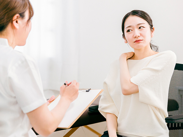 肩こりの相談をする女性
